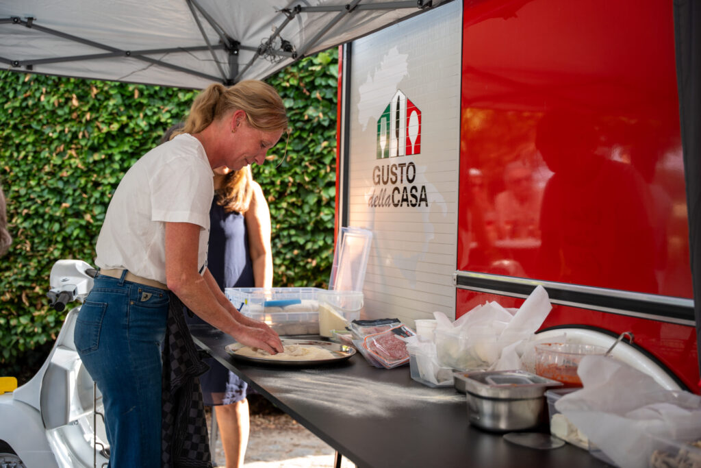 Emmy Blom bereidt een pizza bij de foodtruck van Gusto Della Casa